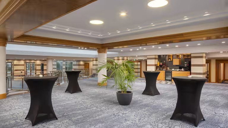 Espace de réception moderne pour conférences : foyer lumineux avec mange-debout et coin rafraîchissements, Hilton CDG